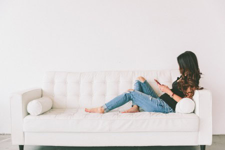 woman answering surveys on the couch