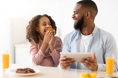 father and daughter eating meal