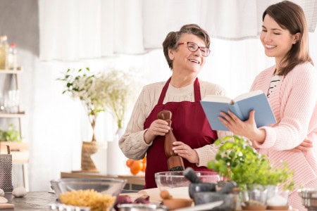 mother and daughter smiling and cooking dollar tree food