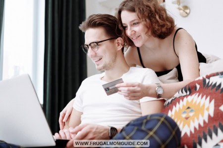 man and woman smiling with laptop and credit card