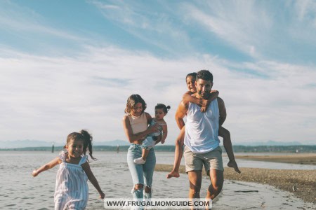 mom, dad and 3 daughters playing at beach