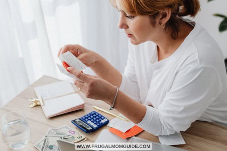 woman with cash, laptop and bills
