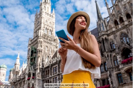 young female tourist with cellphone in front of town hall building in Munich