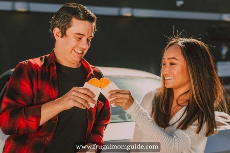 smiling man and woman holding hash browns